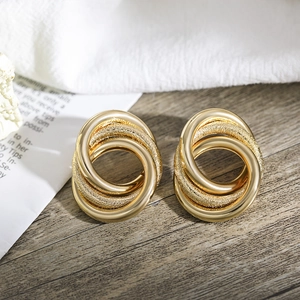 Details von ineinandergreifenden Gold-Creolen mit polierten und glitzernden Texturen