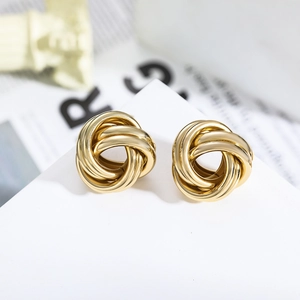 Elegante goldene spiralförmige Knoten-Ohrringe mit Strasssteinen auf minimalistischem Dekor