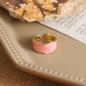 Detalle del anillo de esmalte rosa marmoleado con bordes dorados ondulados