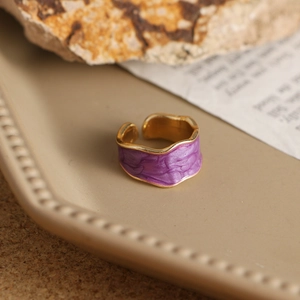 Vista macro de anillo ondulado de esmalte púrpura con bordes dorados y diseño ajustable