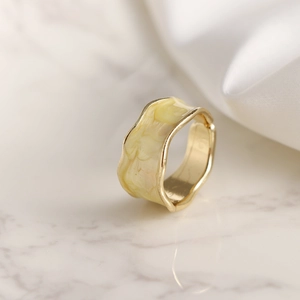 Anillo dorado con bordes ondulados y esmalte crema efecto mármol, banda abierta
