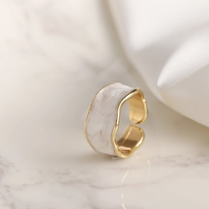 Anillo abierto dorado minimalista con esmalte jaspeado blanco y bordes ondulados