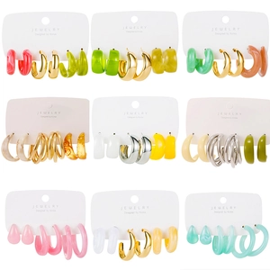 Nine variations of C-shape acetate and resin earring sets on white jewelry cards