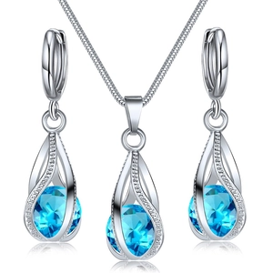 Détail de parure de bijoux argentés avec pendentifs en cristal bleu et zircons blancs