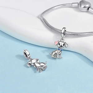 Detailed close-up of a S925 silver dog charm with pink enamel ears on a snake chain bracelet