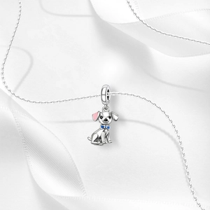 Macro view of S925 sterling silver dog charm with pink ear and blue bow tie detail