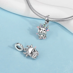 Detail of silver S925 cow charm featuring colorful enamel flowers and gemstone accents
