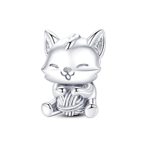 Macro detail of a silver fox charm holding a ball of yarn for DIY bracelets