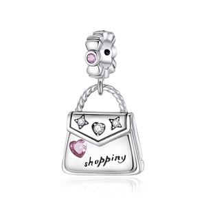Macro shot of silver handbag charm with pink heart stone and shopping engraving