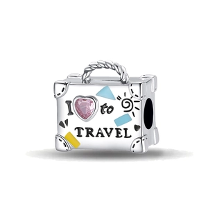 Macro shot of a suitcase charm with a pink heart gem and colorful enamel travel theme