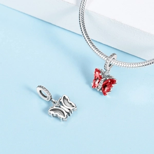 Dettaglio macro di charm a farfalla rossa con marchio S925 argento e zirconi lucidi