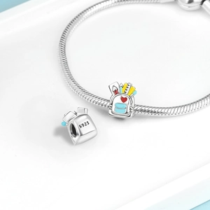 Macro detail of S925 silver schoolbag charm with colorful enamel heart and pencil elements