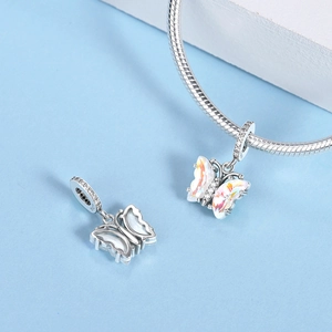 Dettaglio macro dello charm farfalla in argento S925 con ali iridescenti e piccoli zirconi