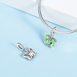Vista macro di un ciondolo a farfalla in argento S925 con gemma verde e micro pavé lucido