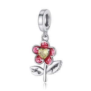 Détail d'un pendentif fleur en argent S925 avec émail rouge, pierre cœur jaune et gravure