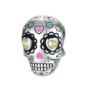 Macro detail of silver skull charm with colorful floral enamel and yellow heart gems