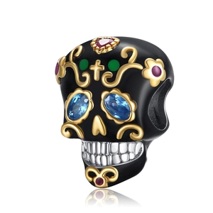 Macro detail of skull bead with blue gemstone eyes and colorful enamel accents