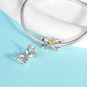 Macro detail of S925 sterling silver infinity charm with blue and yellow enamel figures