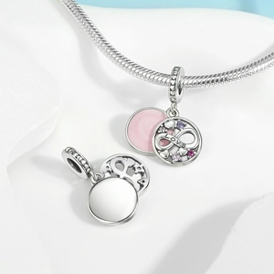 Macro shot of silver infinity heart charm with purple zircons and Love engraving
