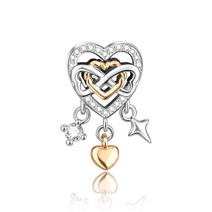 Macro shot of silver heart charm with infinity symbol and dangling star accents