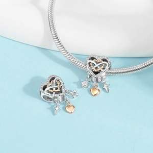 Macro shot of silver heart charm with rose gold infinity symbol and cubic zirconia