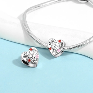 Detail of silver heart charm with Love Mom engraving and mother-child sketch for DIY bracelets
