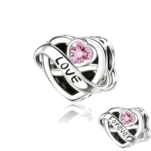 Macro shot of silver heart charm with pink gemstone and Forever Love engraving