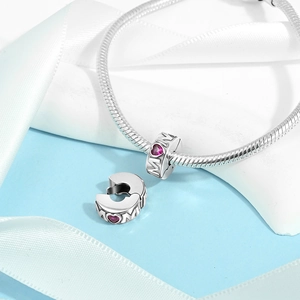 Macro shot of silver snake chain bracelet with heart pink gemstone MOM pendant