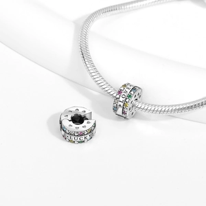 Detailed macro of silver charm with colorful zircons and engraved Love and Lucky words