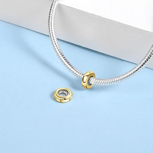 Macro shot of gold-plated spacer beads with mirror finish on a silver snake chain