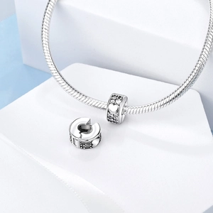 Macro detail of silver plated charm with hollow hearts and cubic zirconia stones
