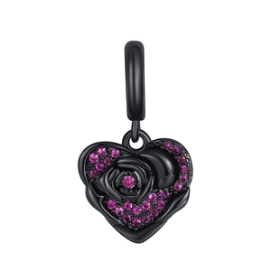 Detail of black-plated heart pendant with rose motif and pink crystals on white background