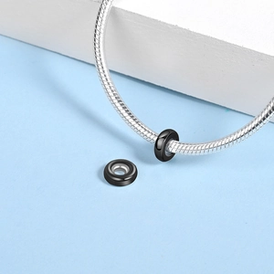 Macro shot of black polished silicone stopper beads on a silver snake chain bracelet