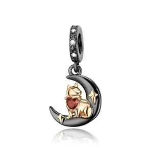 Detail of dog on moon pendant with red heart gemstone and black gold plating