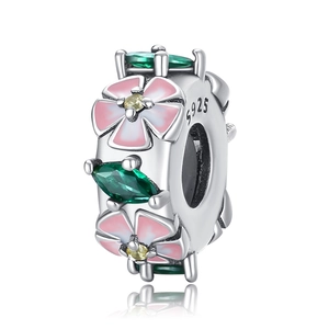 Macro detail of S925 silver charm with pink enamel flowers and green gemstone accents