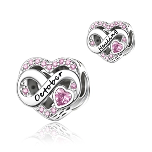 Macro view of silver heart charms with pink stones and October Healing engravings