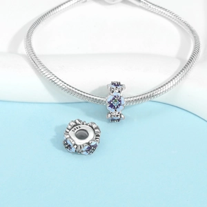 Macro shot of S925 silver snake chain bracelet with blue and purple floral enamel charms