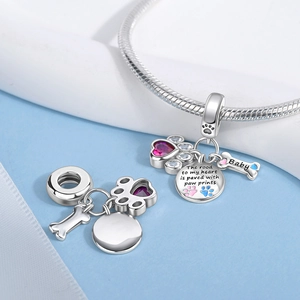 Detailed view of silver pet paw charms with multi-color stones and Baby bone pendant