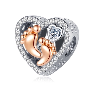 Detail of silver heart charm with rose gold baby footprints and sparkling zirconia