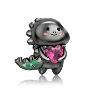 Makro-Detail von dunklem Metall-Dinosaurier-Anhänger mit rosa herzförmigem Kristall