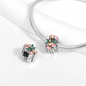 Macro shot of S925 silver floral charm with pink enamel petals and green leaves