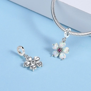 Detail view of flower pendant with white opal petals and pink gemstone center on silver