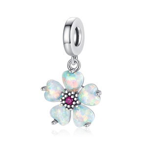 Macro detail of silver flower charm featuring iridescent opal petals and a pink gemstone