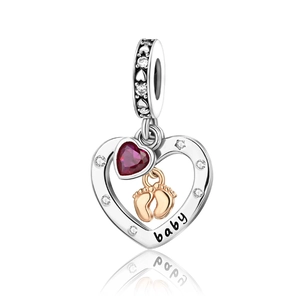 Detailed view of silver heart charm featuring red gem, gold baby feet, and baby engraving