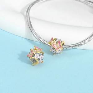 Detailed view of pink enamel butterfly and cherry blossom charms on a silver snake chain