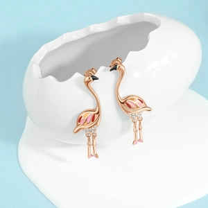Orecchini a fenicottero in oro rosa con smalto e zirconi su uovo decorativo bianco