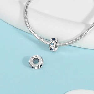 Detailed macro view of S925 sterling silver beads with blue gems on snake chain bracelet