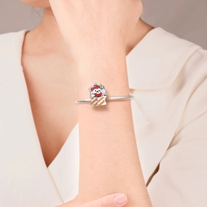 Detail of a silver charm bracelet with a cute puppy in a gift box worn by a woman