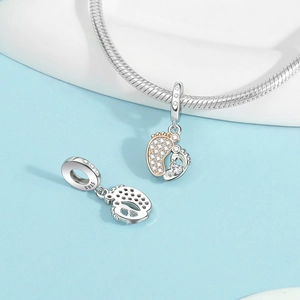 Macro shot of S925 sterling silver baby footprint charm with sparkling heart-shaped zircon