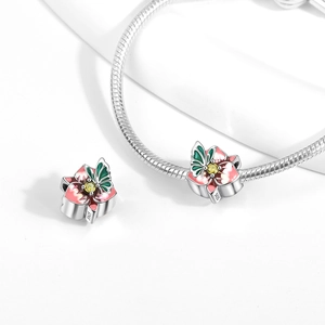 Detailed macro shot of S925 silver butterfly charm with pink enamel and yellow zircon